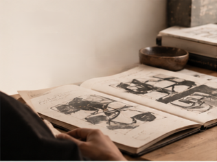 Hands turning the pages of a sketchbook
