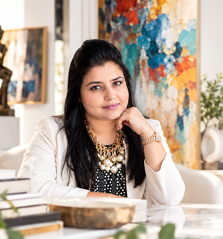 Ragini Mittal seated at a table in her sunlit studio