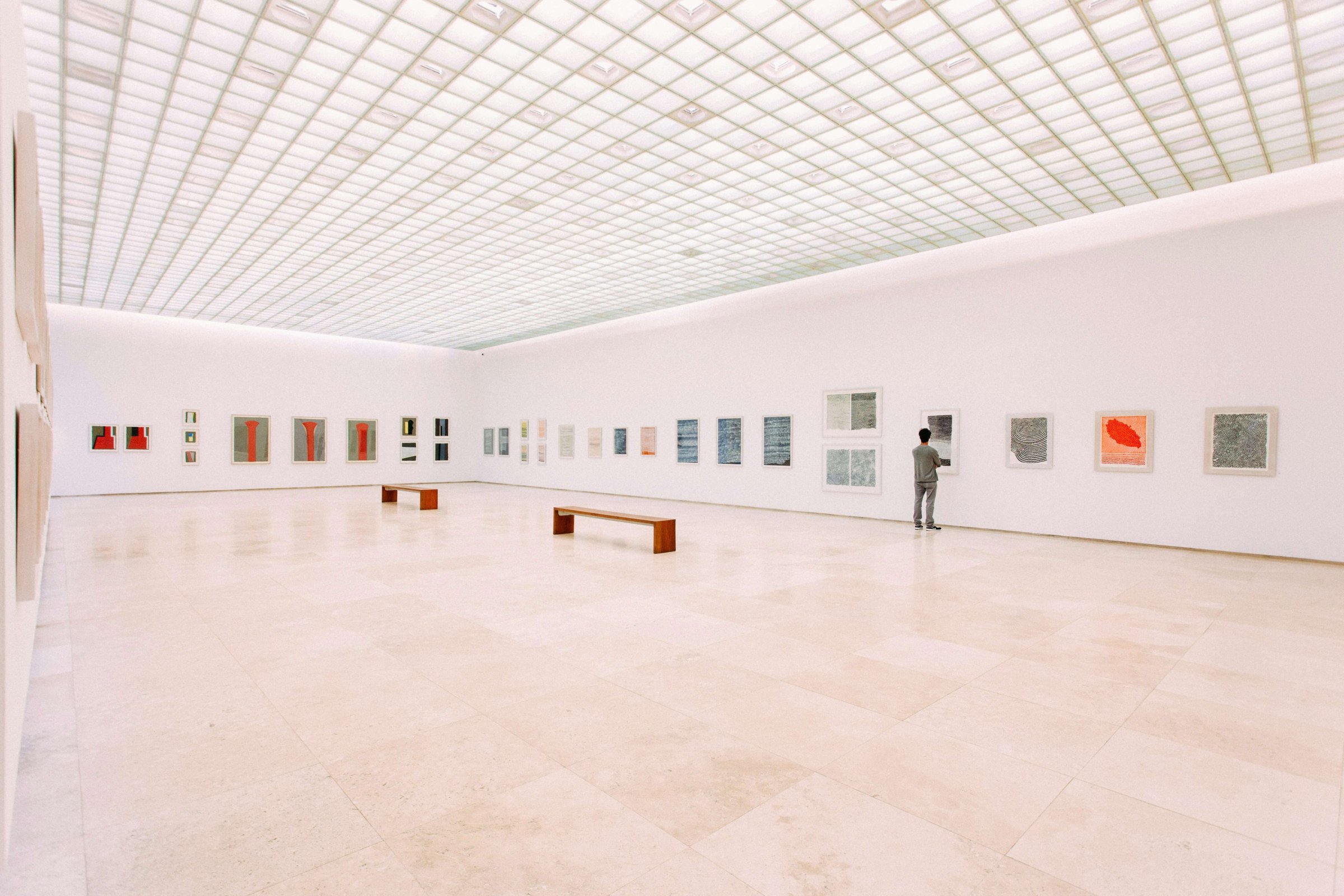 A collector studying framed works in a gallery